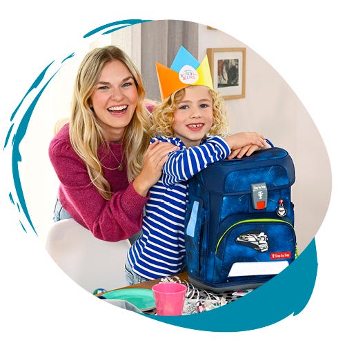 Kinder packen Süßigkeiten und ein Kuscheltier aus einer Einhorn-Schultüte