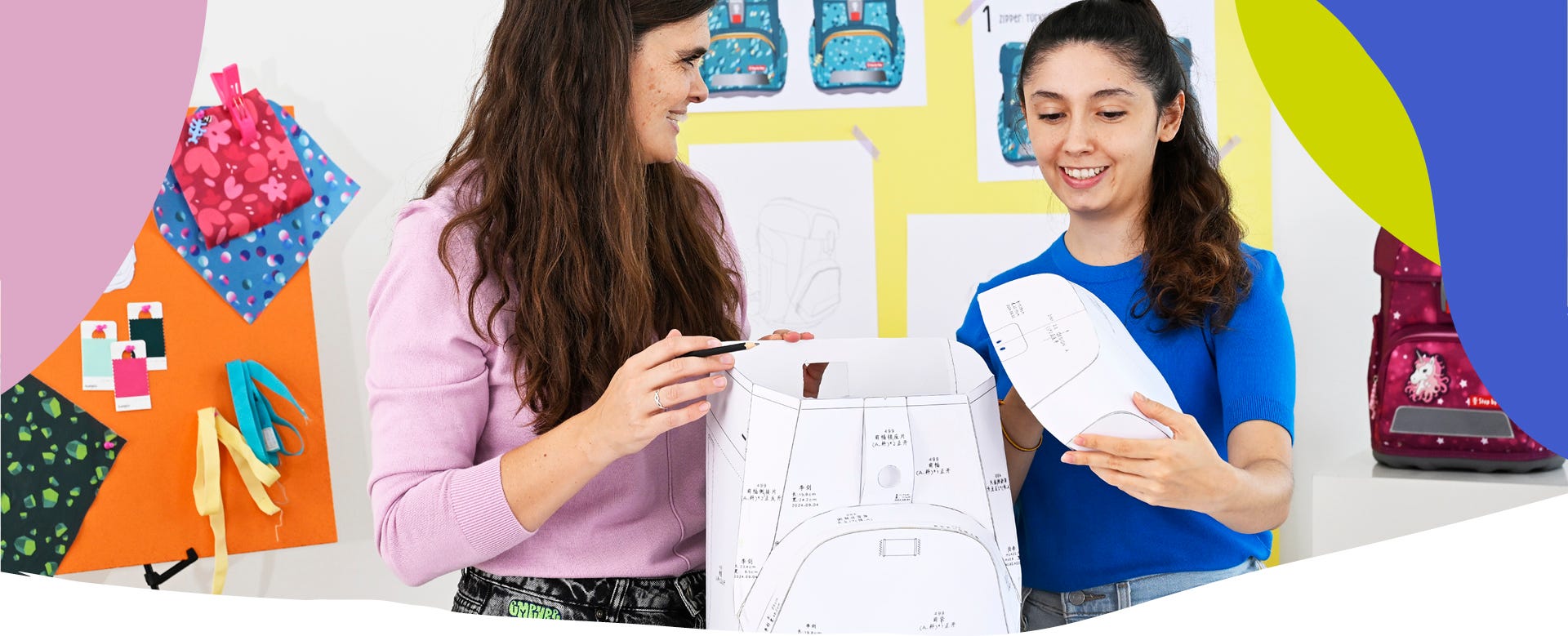 Zwei Personen arbeiten mit Papierprototyp und Entwurfsskizzen an der Entwicklung eines Schulranzens.
