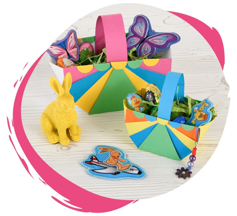 Bunte, selbstgebastelte Osterkörbe aus Papier stehen nebeneinander und sind mit kleinen Geschenken befüllt.