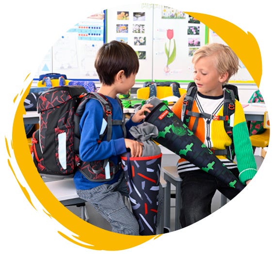 Zwei Jungen sind in der Schule und halten ihre Schultüten