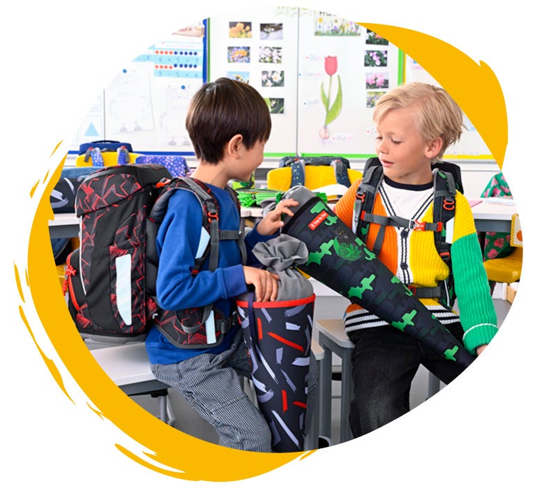 Zwei Jungen sind in der Schule und halten ihre Schultüten