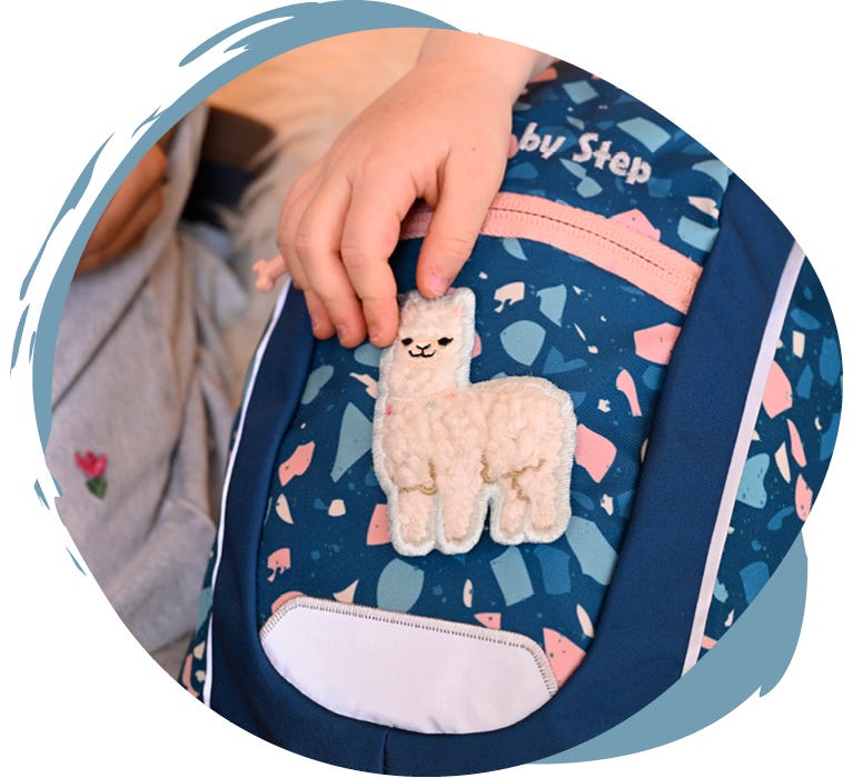 Dunkelblauer Kindergartenrucksack mit flauschigem Alpaka-Motiv auf der Vorderseite.