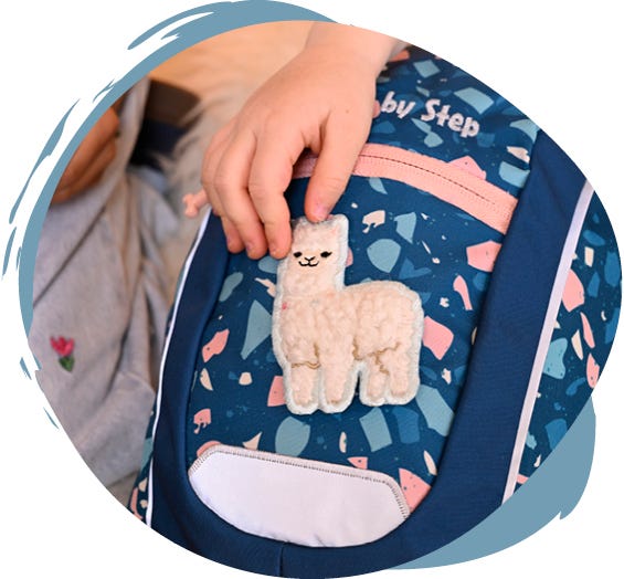 Dunkelblauer Kindergartenrucksack mit flauschigem Alpaka-Motiv auf der Vorderseite.