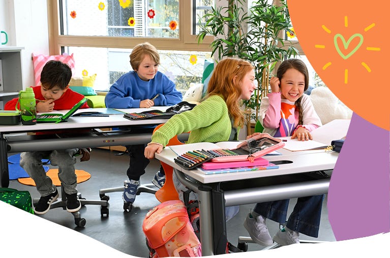 Kinder arbeiten im Klassenzimmer mit Federm&auml;ppchen, Stiften und Heften an ihren Schreibtischen in einer hellen Lernumgebung.