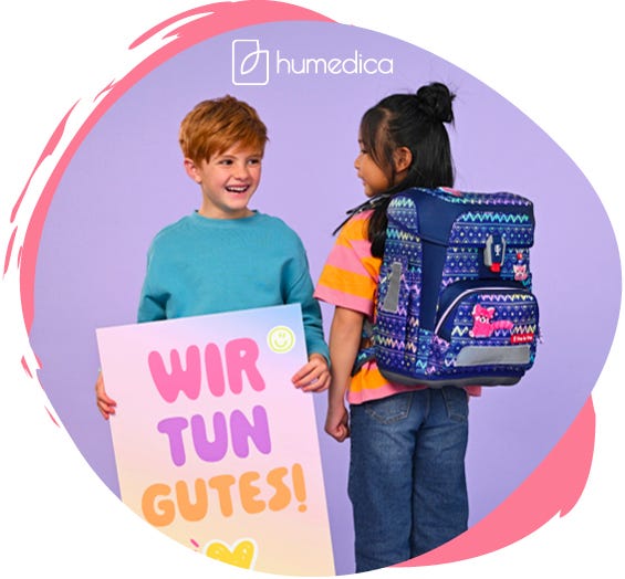 zwei Kinder pr&auml;sentieren einen bunt gemusterten Schulranzen mit einem pinken Panda als Frontmotiv