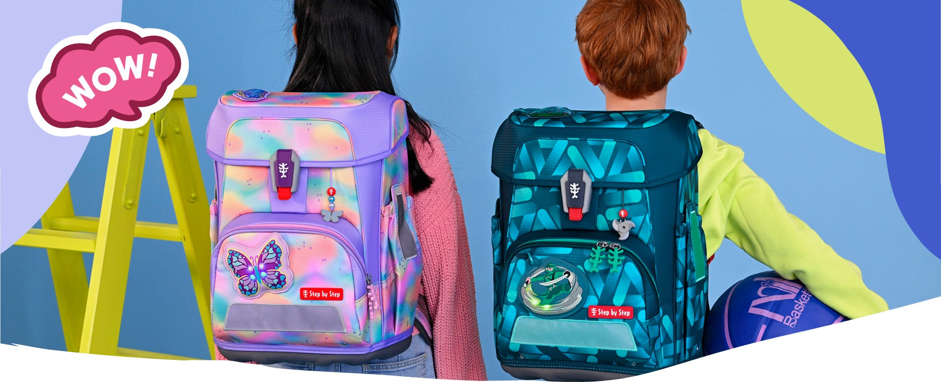 Zwei Kinder präsentieren einen pastellfarbenen Schulranzen mit Schmetterlingsmotiv und einen dunkelblauen Schulranzen mit Sportwagen-Motiv. Text: ‚WOW!‘