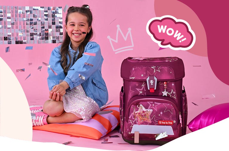 Kind neben einem dunkelrosa Schulranzen mit Sternenmuster und Glitzer-Details vor rosafarbener Kulisse. Text: ‚WOW!‘.