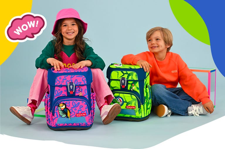Zwei Kinder pr&auml;sentieren einen pink-blauen und einen neongr&uuml;n-blauen Schulranzen im Neon-Design. Text: &sbquo;WOW!&lsquo;.