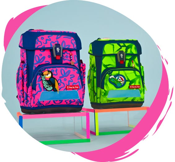 Neonpinker und neongr&uuml;ner Schulranzen mit Motiven und reflektierenden Elementen auf farbigen Podesten.