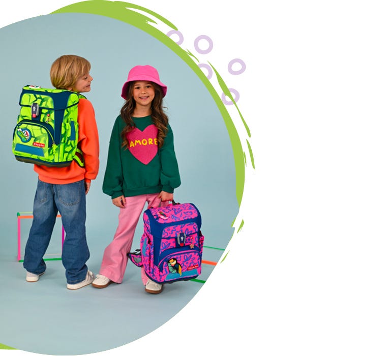 Zwei Kinder pr&auml;sentieren einen neongr&uuml;nen Schulrucksack und einen pink-blauen Schulranzen aus einer Neon-Kollektion.