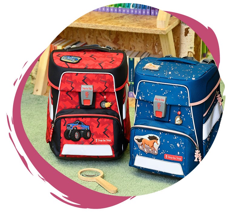 Zwei Schulranzen auf einem Teppichboden: links ein roter mit Monstertruck-Motiv, rechts ein blauer mit Pferde-Design.