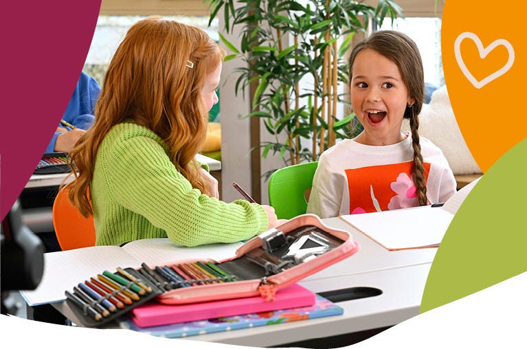 Zwei Kinder arbeiten gemeinsam im Klassenraum an einer Schulaufgabe.
