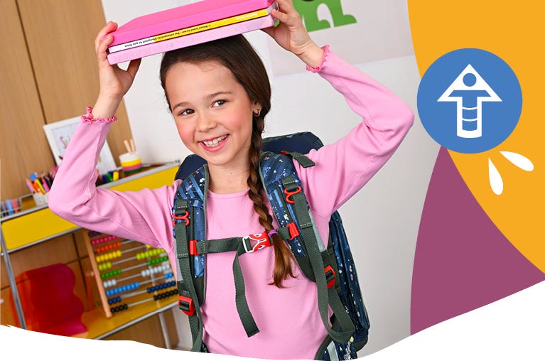Person mit ergonomisch getragenem Schulrucksack und geschlossenem Brustgurt im Klassenzimmer. Symbol für Ergonomie und Tragekomfort.